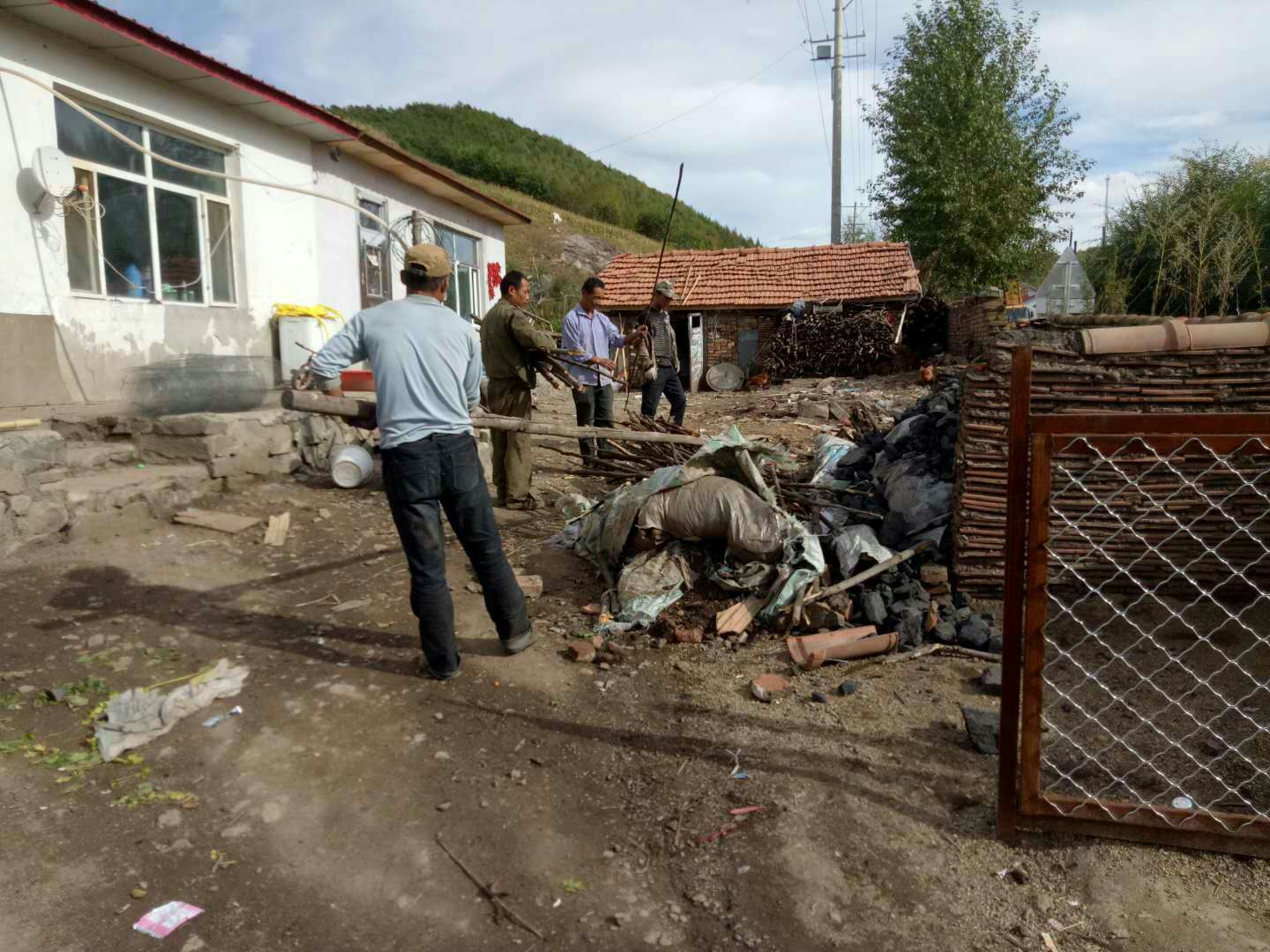 机关干部入村帮助贫困户打扫庭院